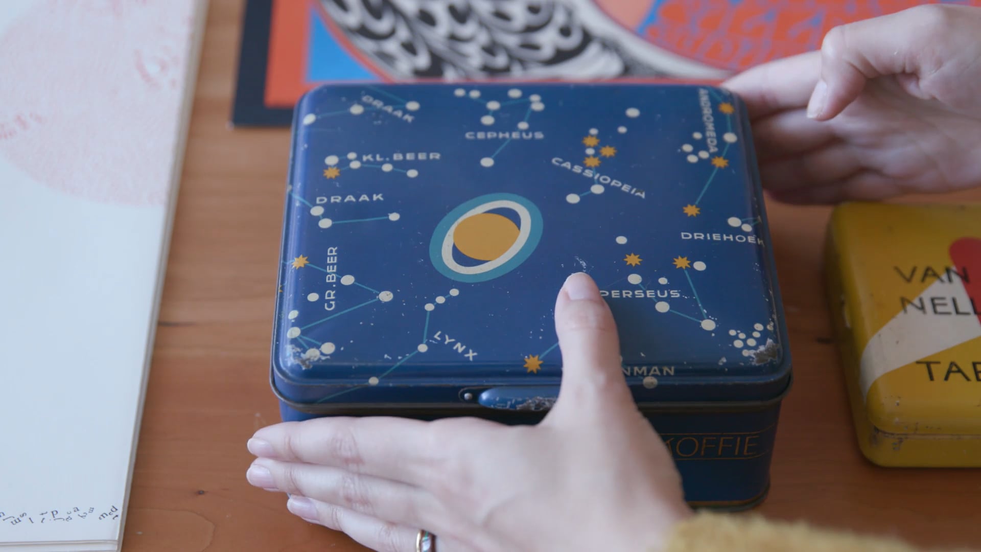 A blue tin designed by Jakob Jongert being placed on a table at Letterform Archive.